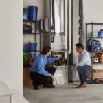 Carrier dealer and homeowner talking by HVAC system in basement